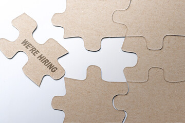 Fototapeta premium Piece of missing jigsaw puzzle with We're Hiring text