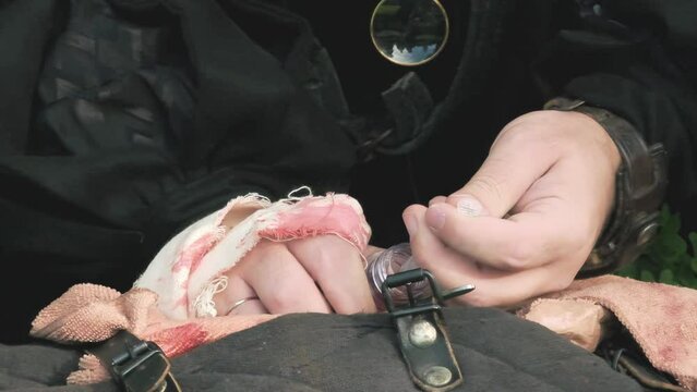 LARP (live action role play) scene: a healer cleric taking a potion from a tube with a syringe, to heal a wounded comrade. Detail shot, slow motion.