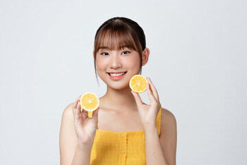 Organic cosmetics concept. A young girl with clean skin holds lemon slice near her face