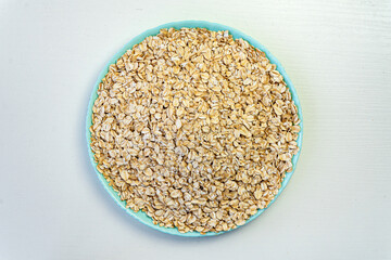 top view, Oat flakes in blue plate on white background,