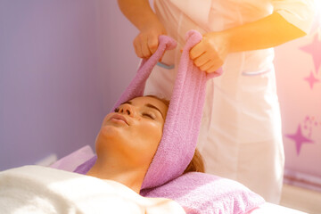 Relaxing massage. European woman getting head massage in spa salon, side view