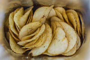 inside is open pack of potato chips. fatty junk food snack point. package. open pack of chips. View from above. top view.