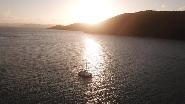 Catamaran in calm waters of Hook Island reef between Nara and Macona Inlets in Whitsunday Islands during Golden Hour Sunset, Queensland, Australia