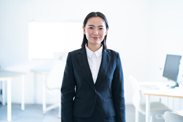 オフィスにいる若手のスーツを着た日本人女性