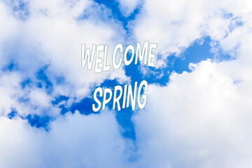 Blue sky with clouds and words, Welcome spring springtime. Spring background