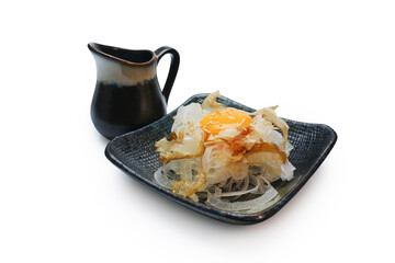 Katsuobushi on sliced onions served with raw egg on top, sprinkled with sesame seeds