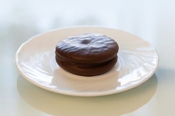 Tasty choco pie on white tiled table, close up.