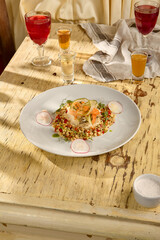 Baked white fish fillet with a ptitim and vegetable garnish, a well-balanced and flavorful dish