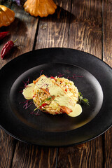 Salmon steak over rice with a lemon sauce, elegantly served on a sleek black plate