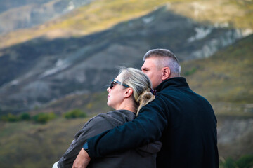 Hugging couple in the mountains enjoying the scenery