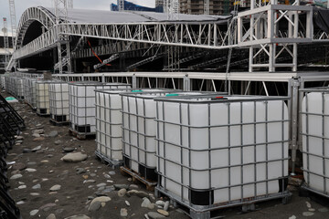 Bulk liquid chemicals in storage and transfer container. Chemical storage containers. IBC International Bulk Containers. tank, tote,  pallet. iron, metal collapsible stadium and stage with roof Batumi