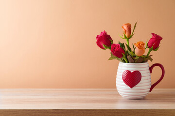Happy Valentine's day concept with rose flowers bouquet on wooden table over trendy peach color background