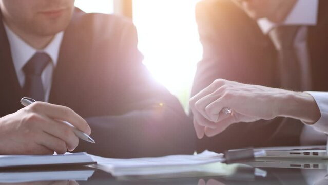 Closeup businessman sign contract or legal document with pen in his hand during corporate meeting for business deal