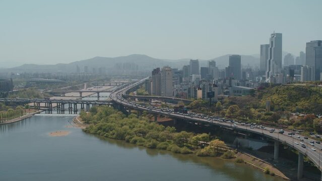 Drone Shot of Seoul Skyline and Bridge Over the Han River With Mountains in Background