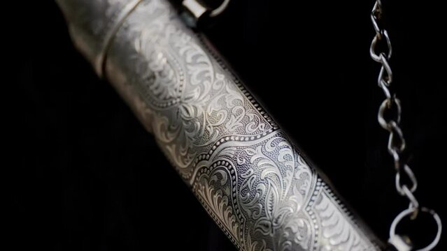 Close-up of a silver dagger on a dark background.