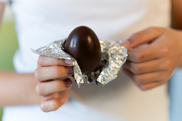 chocolate egg in hands of a teenage girl close-up