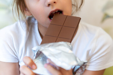 girl with long hair biting chocolate