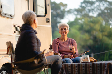 Multi-generation family sitting and eating outdoors by car, caravan holiday trip, Family vacation parents enjoy bonding camping in woods travel