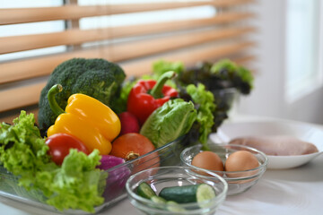 Composition of nutritious food with variety fresh vegetable, meat and eggs for healthy diet on white table.