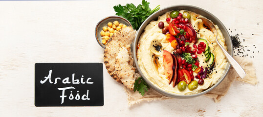 Hummus. Large bowl of homemade hummus garnished with chickpeas, vegetables and olive oil. Middle east food.