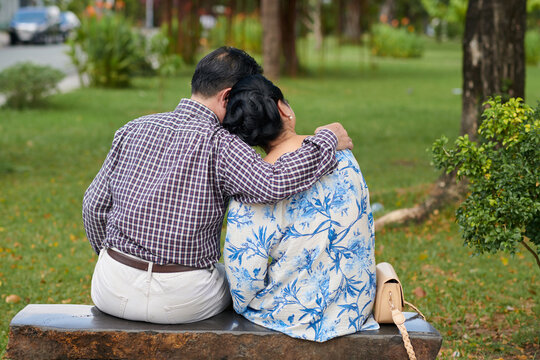 Senior Couple In Love Cuddling In City Park, View From Behind