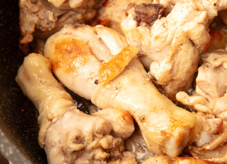 Chicken meat is stewed in a frying pan