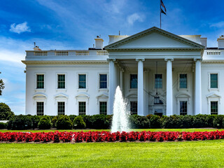 The white house located in the American capital of Washington DC, under a blue sky and clouds, in...