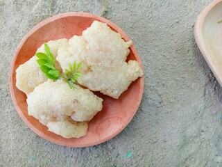 gejos or traditional Indonesian snacks on a wooden plate with a textured background, snacks made from starch mixed with grated coconut and spices then fried. chewy and delicious snack. homemade