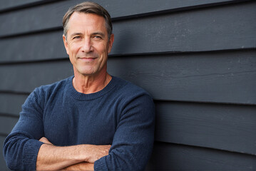 Portrait shot of an attractive, successful and happy middle aged man male arms folded outside wearing a blue sweater - obrazy, fototapety, plakaty