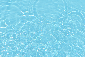 Bluewater waves on the surface ripples blurred. Defocus blurred transparent blue colored clear calm water surface texture with splash and bubbles. Water waves with shining pattern texture background.