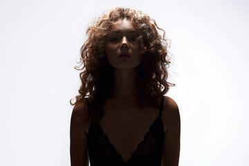curly Hair Girl silhouette. Beautiful young Woman in white studio
