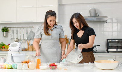 Asian cheerful professional female pastry bakery baker chef housewife with friend standing smiling...