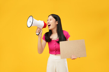 Portrait of a young Asian woman shouting angrily using a megaphone and holding paper. Isolated on a...