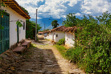 Fototapeta na wymiar Narrow street of heritage town Guane - El Camino Real trail Barichara. Historic city in Santander department with cobbled streets and beautiful colonial architecture. Most beautiful town in Colombia.