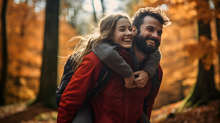 Happy couple enjoying piggybacking in a forest in autumn afternoon