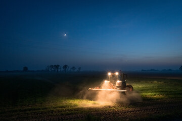 Evening with a tractor in a field with a crescent moon