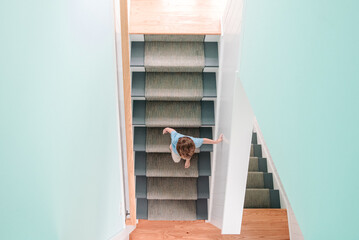 Overhead view of young boy walking down staircase