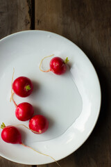 Bright, fresh, red radishes on a white plate