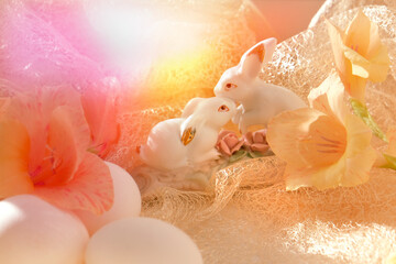 Easter home decorations, couple rabbits and fresh flowers. Easter still life. Sunlight and pastel colors