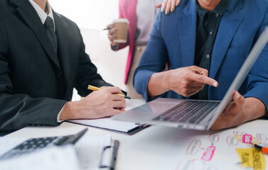 Business representatives meeting pointing on laptop computer. Business team discussing investment plan using data on laptop.
