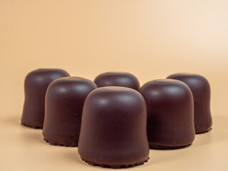 Marshmallows in chocolate glaze on an orange background. Marshmallow close-up.