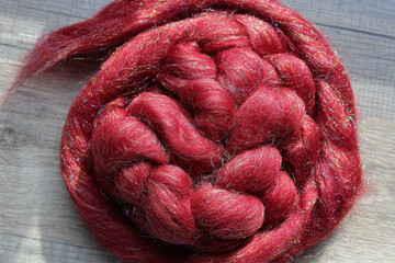 Closeup detail of colourful sheep wool merino, alpaca and silk fibres in a roving pleat, ready for...