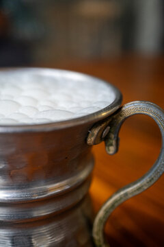 Macro shot of local Turkish ayran in a gray copper glass on a wooden background