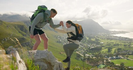 Couple of friends, help and mountain or rock climbing for adventure, travel and fitness support with city or countryside view. People in backpack for trekking teamwork or hands together on a cliff