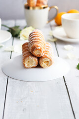 tubes with cream and coffee. on a wooden background. dessert