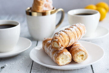 tubes with cream and coffee. on a wooden background. dessert
