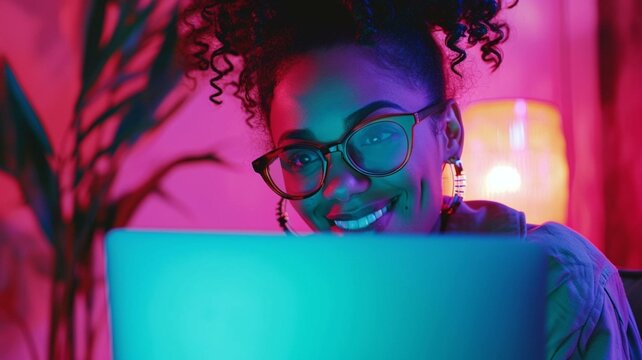 Woman working on laptop in pink neon light