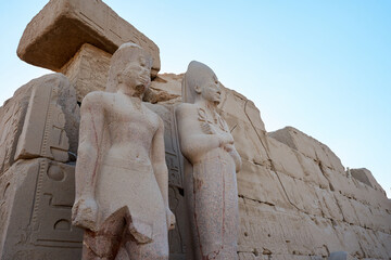 Seated statue of Ramesses II by the First pylon of the Luxor Temple, Egypt. Columns and statues of...