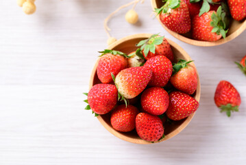 Fresh strawberry fruit in wooden bowl on white background, Top view