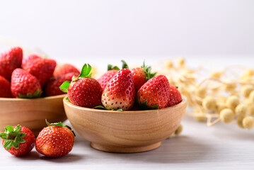 Fresh strawberry fruit in wooden bowl on white background